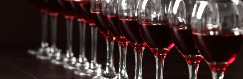 Image of Glasses with tasty red wine, closeup view. Banner design