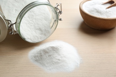 Photo of Pile of baking soda on wooden table