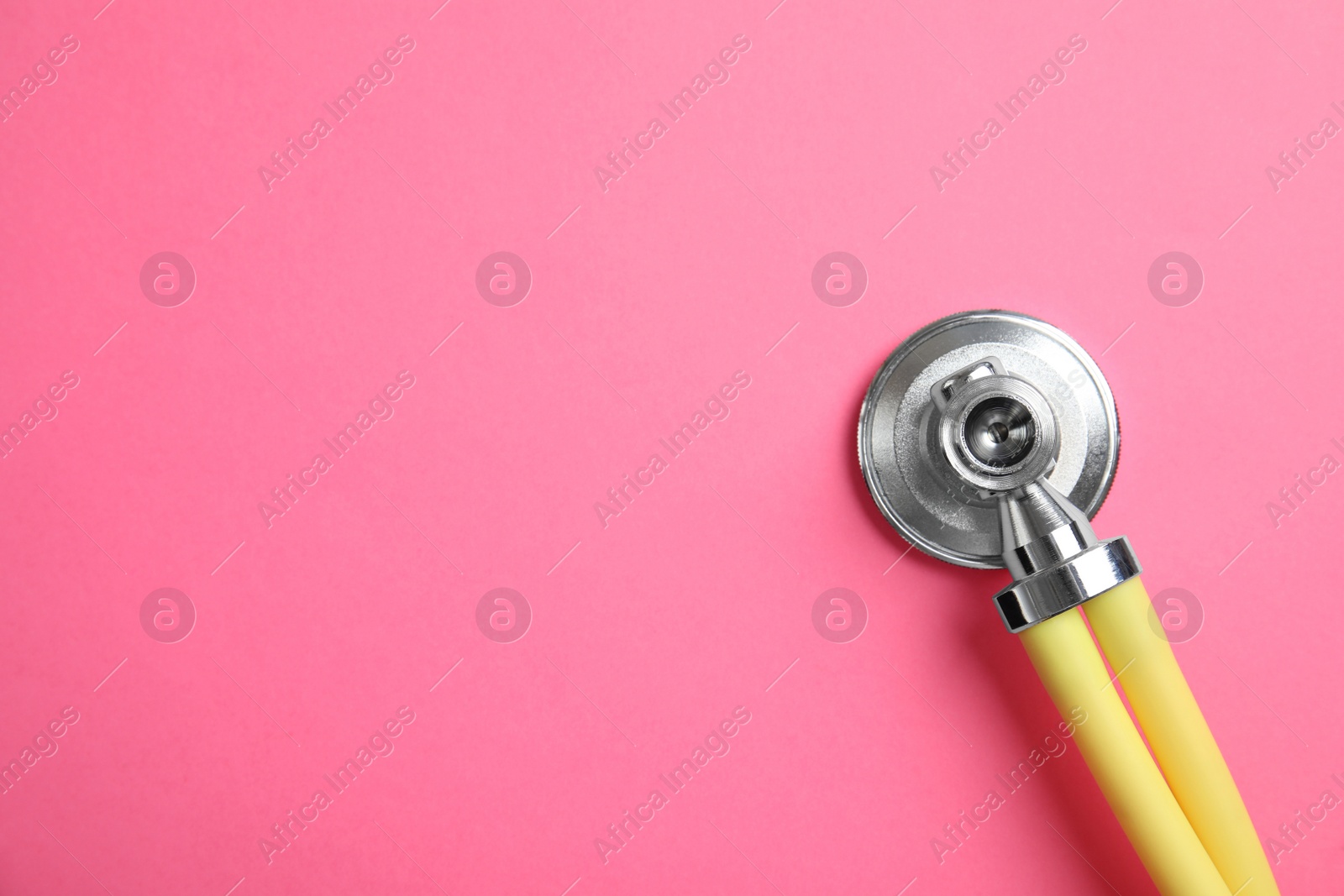 Photo of Stethoscope with space for text on color background, top view. Medical tool