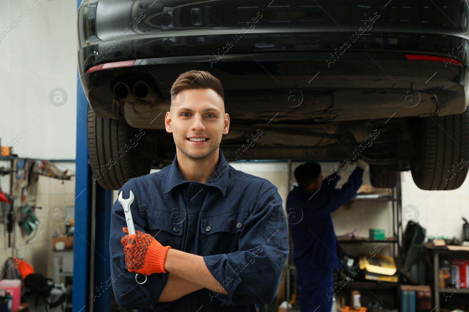 Photo of Portrait of professional mechanic with wrench at automobile repair shop