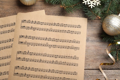 Photo of Flat lay composition with music sheets on wooden background. Christmas celebration