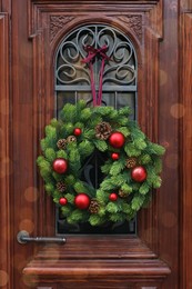 Beautiful Christmas wreath hanging on wooden door