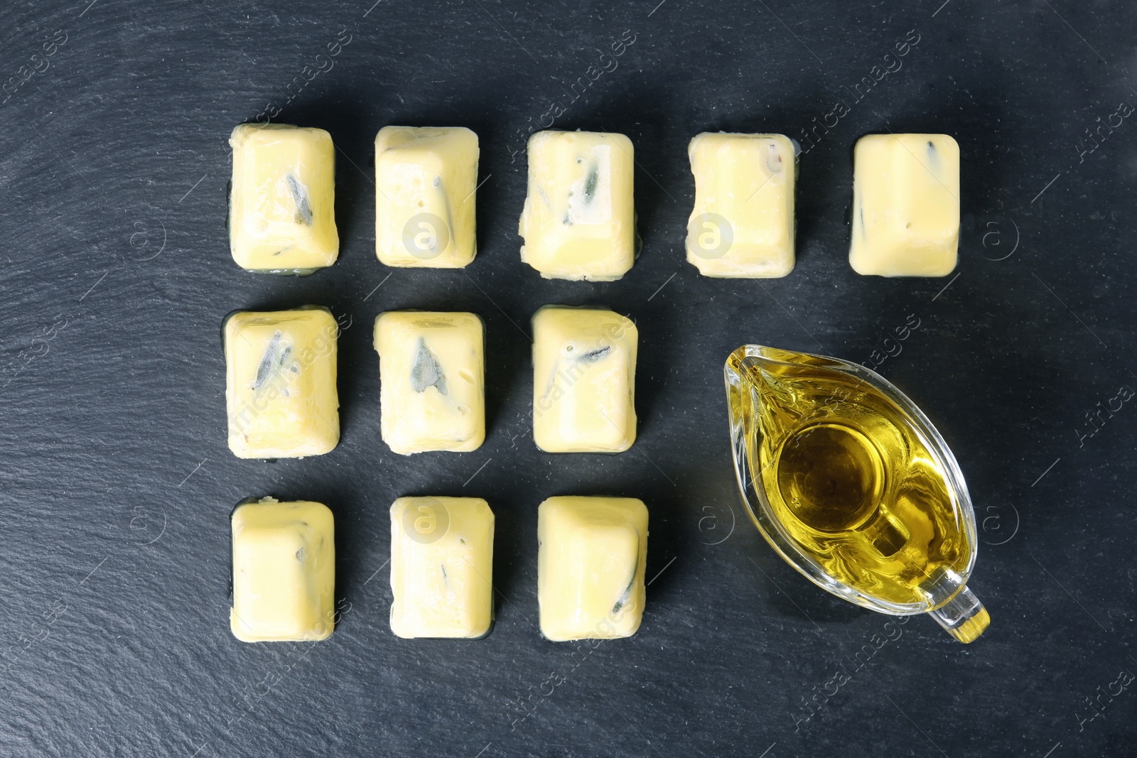 Photo of Flat lay composition with rosemary and olive oil ice cubes on dark background