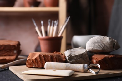 Clay and set of modeling tools on table in workshop