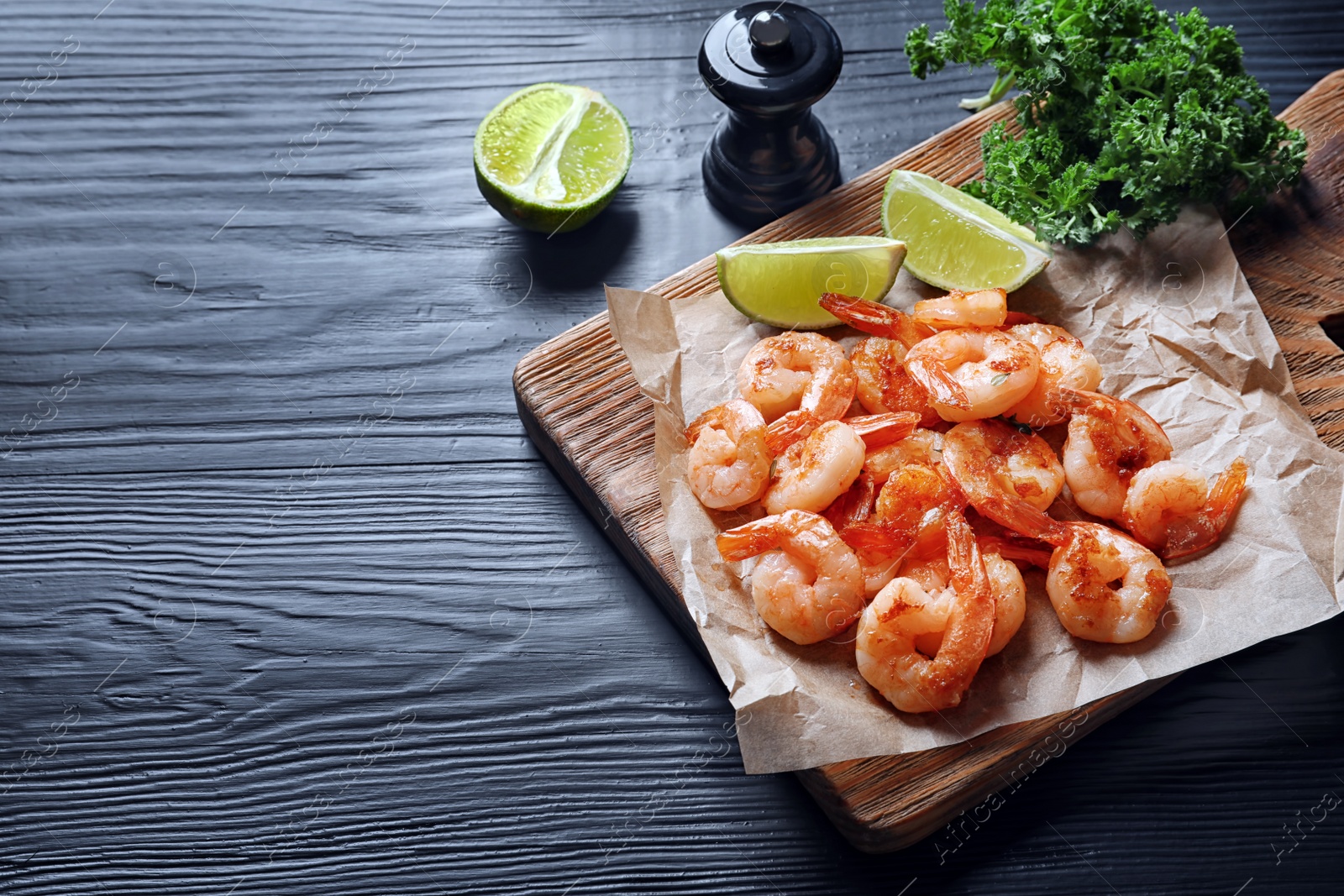 Photo of Board with delicious fried shrimps and lime on wooden background