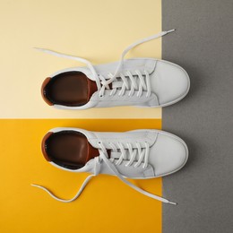 Pair of stylish white sneakers on color background, flat lay