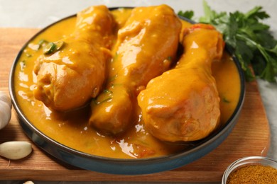 Photo of Tasty chicken curry and ingredients on grey table, closeup