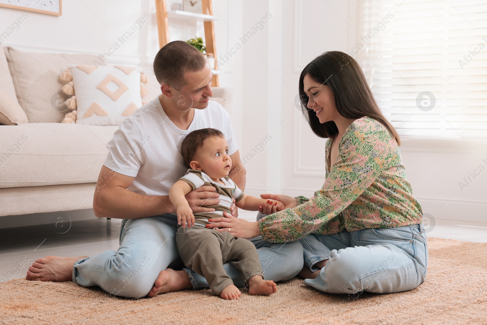 Photo of Happy parents spending time with their cute child at home
