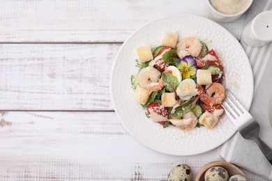 Delicious Caesar salad with shrimps on white wooden table, flat lay. Space for text