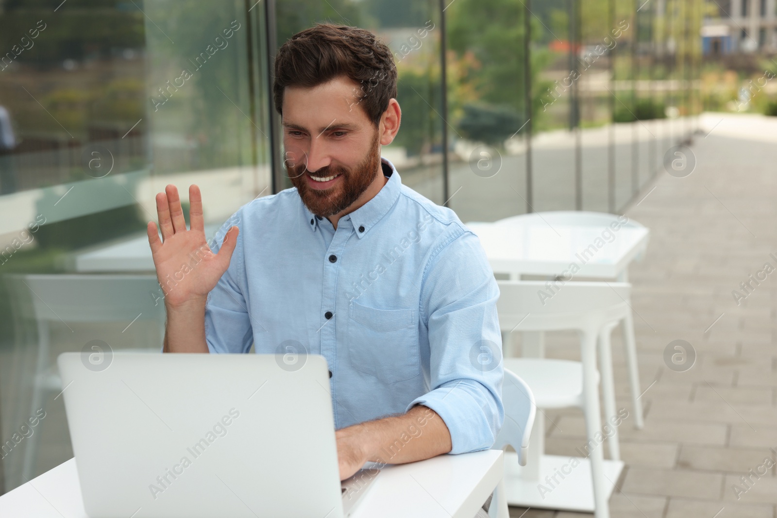 Photo of Handsome man with laptop in outdoor cafe