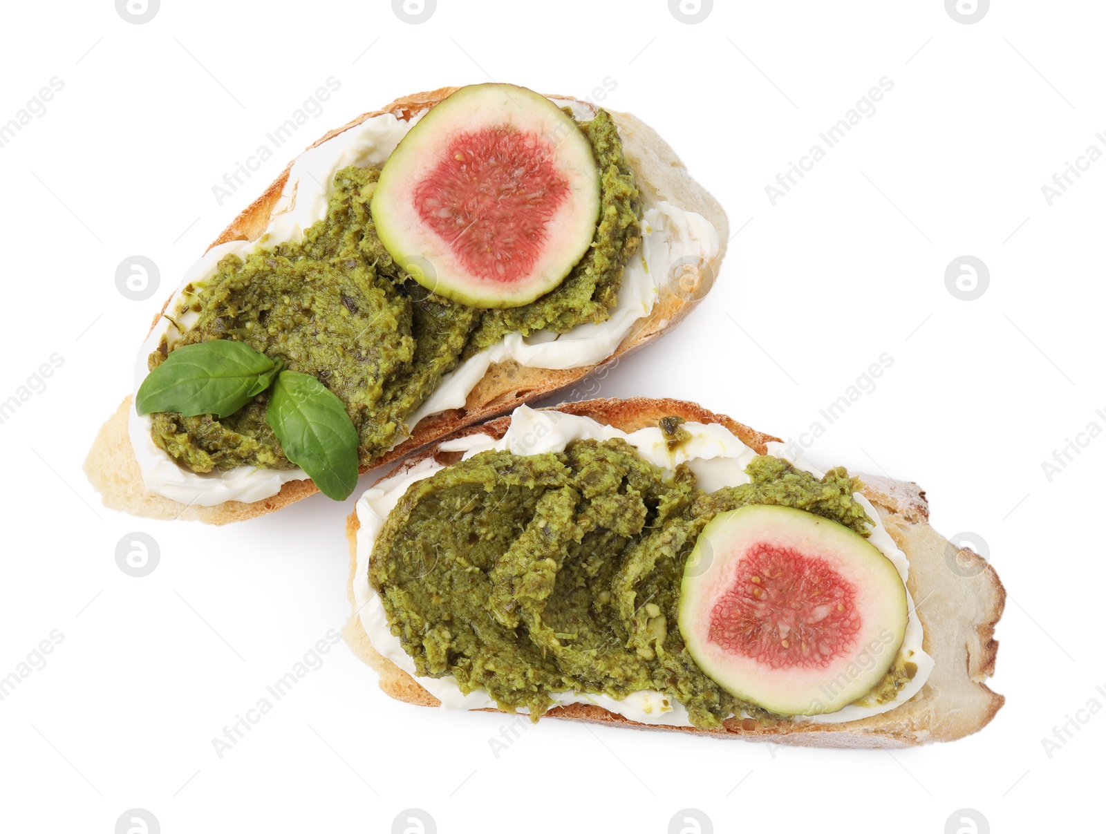 Photo of Tasty bruschettas with cream cheese, pesto sauce, fig and fresh basil on white background, top view