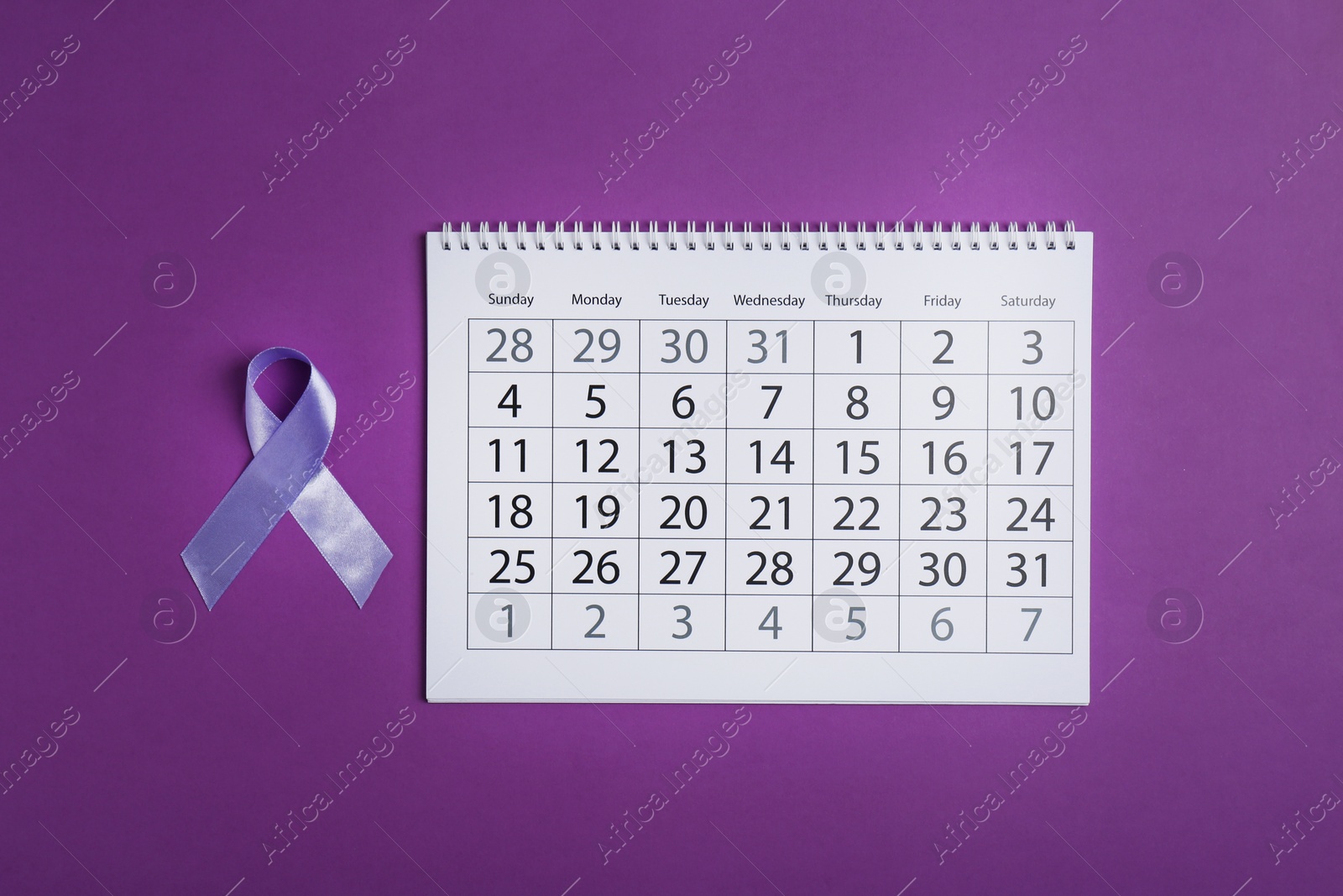 Photo of Purple awareness ribbon and calendar on color background