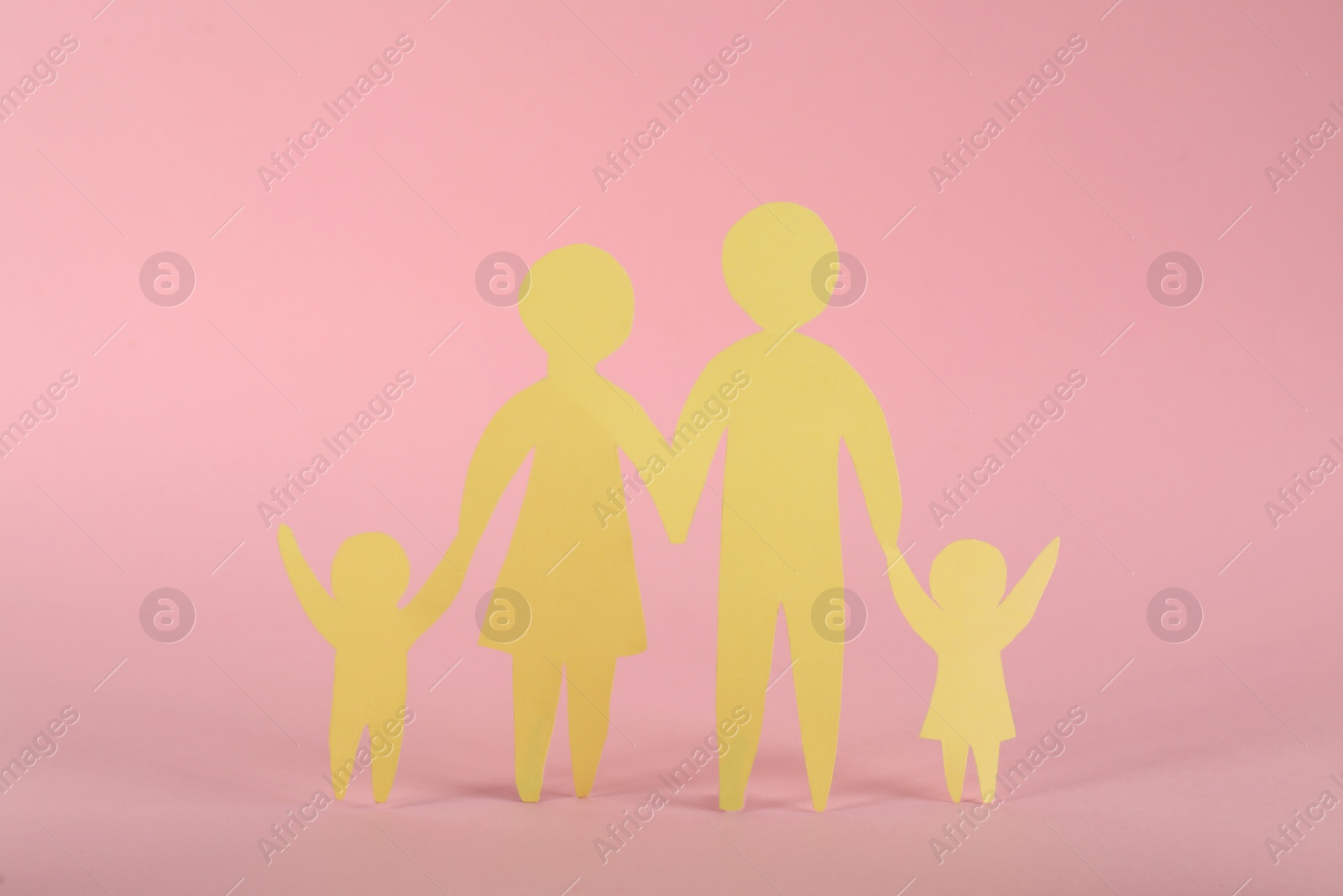 Photo of Paper family figure on pink background. Child adoption concept