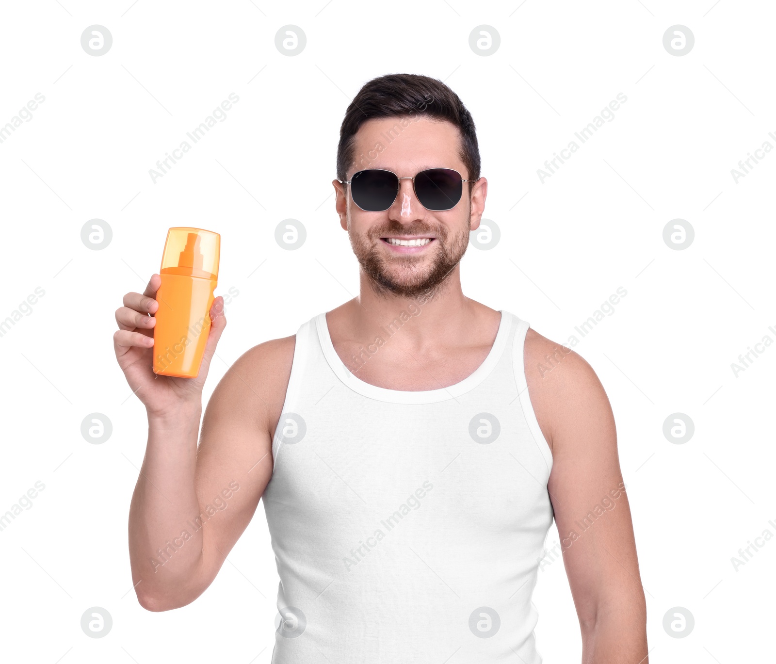 Photo of Handsome man in sunglasses holding bottle of sun protection cream on white background