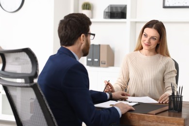 Woman having meeting with lawyer in office, selective focus