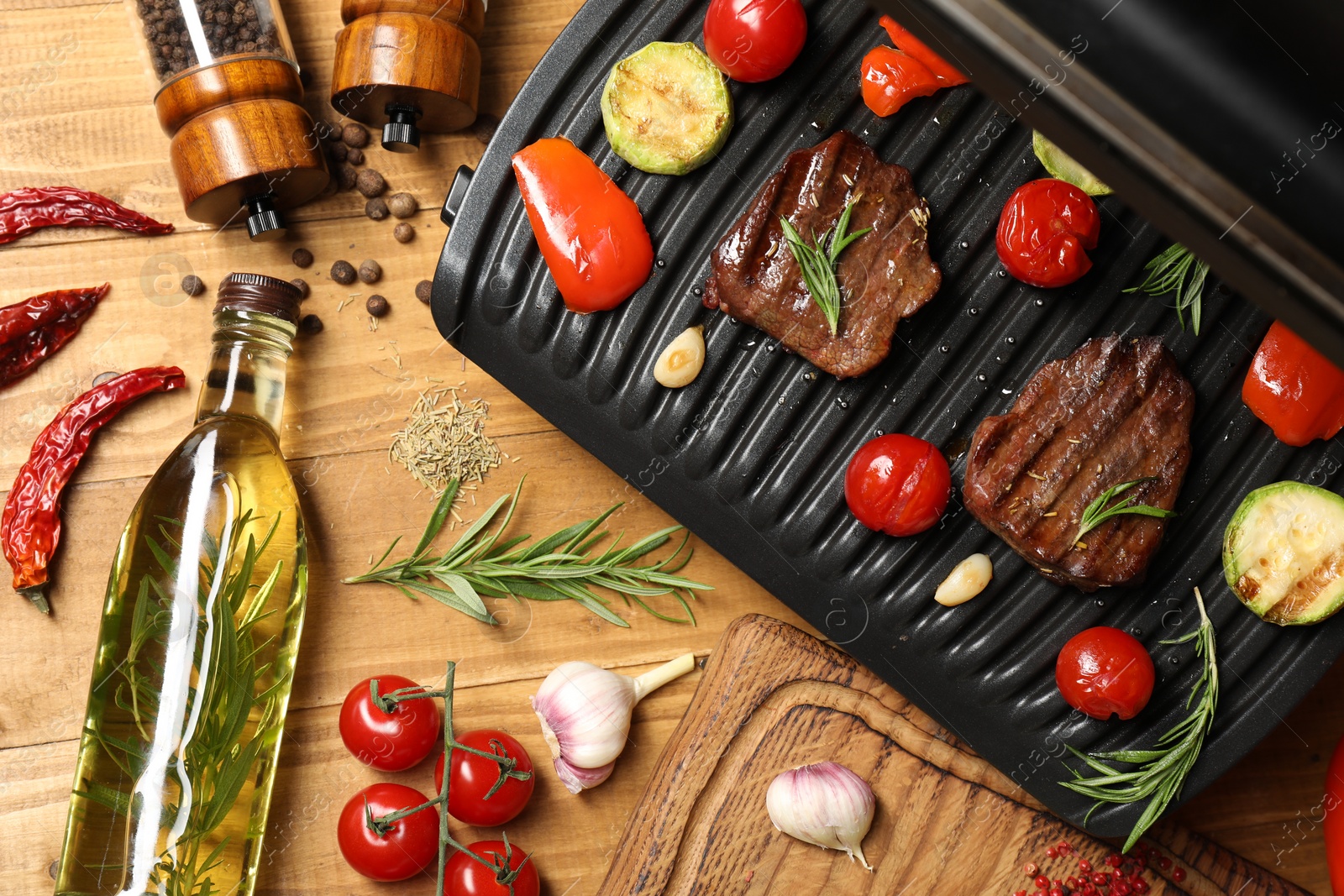 Photo of Flat lay composition with electric grill and different products on wooden table