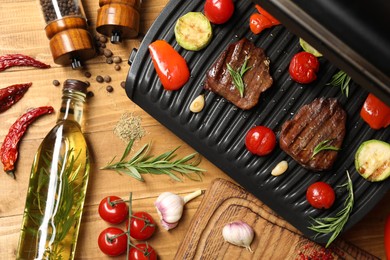 Photo of Flat lay composition with electric grill and different products on wooden table