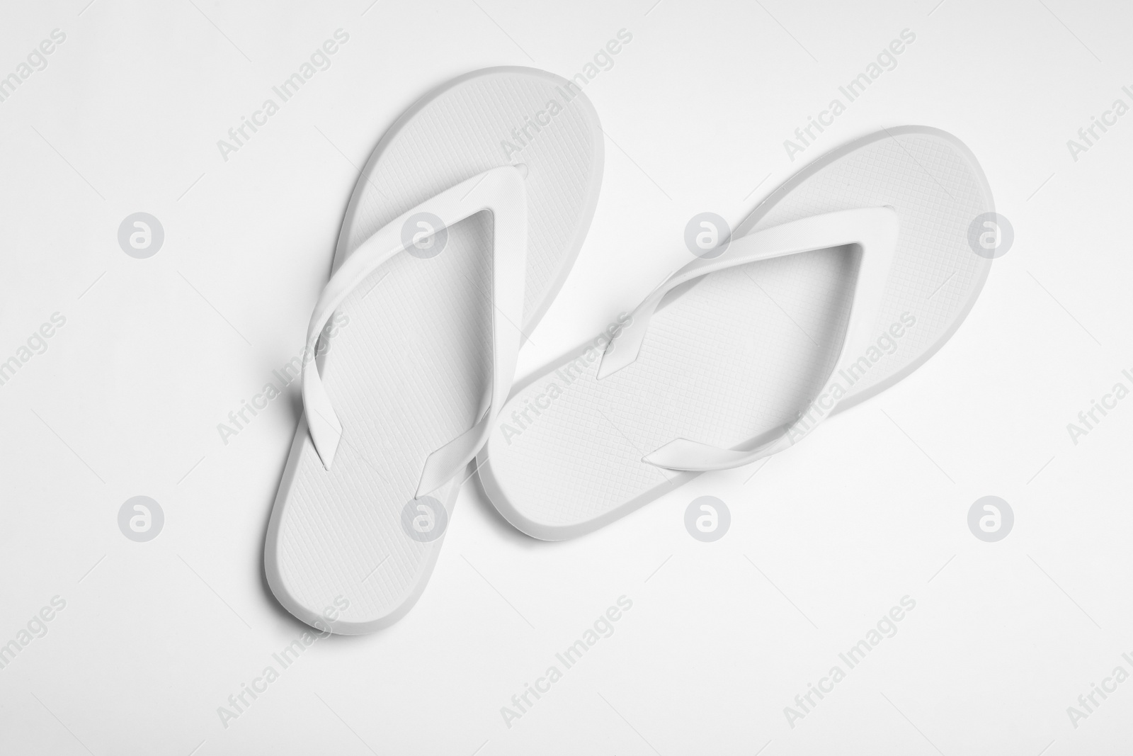 Photo of Pair of flip flops on white background, top view. Beach accessories