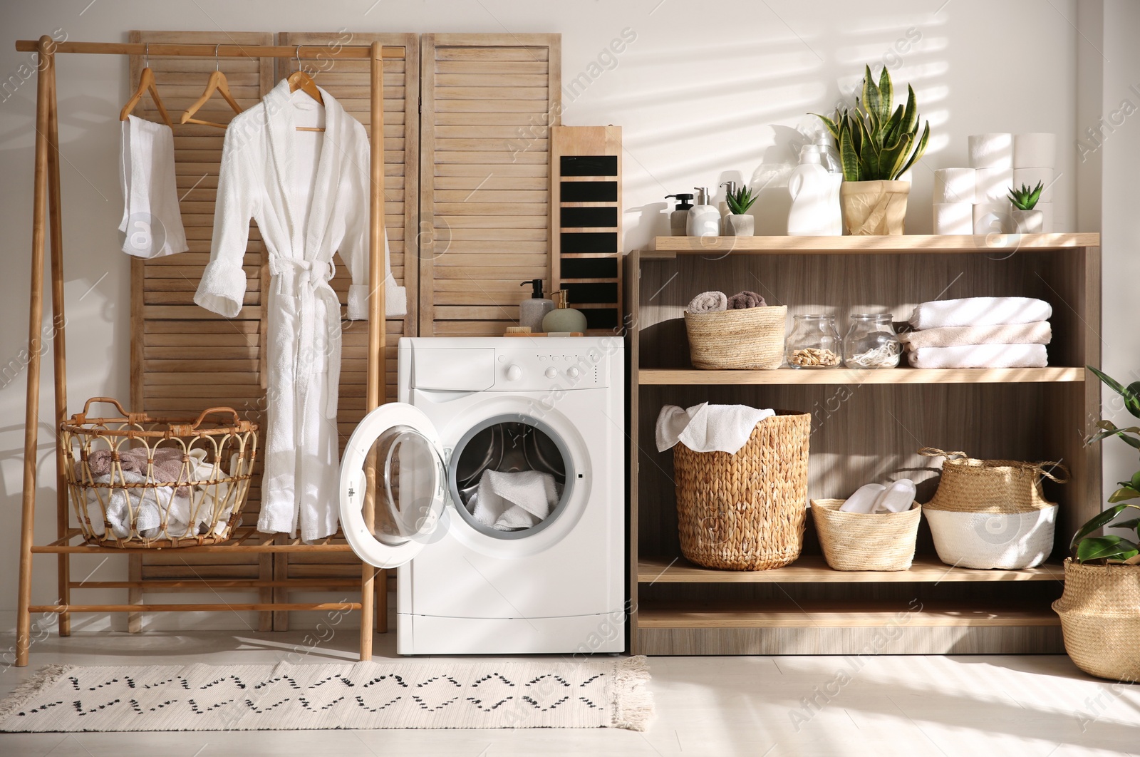 Photo of Modern washing machine and shelving unit in laundry room interior