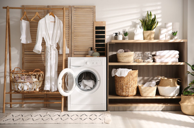 Modern washing machine and shelving unit in laundry room interior