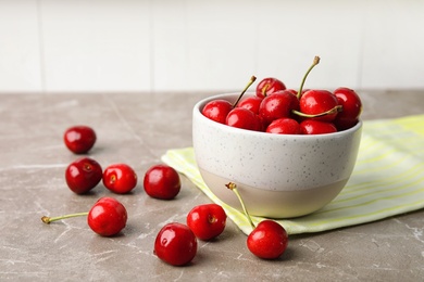 Bowl with sweet red cherries on table