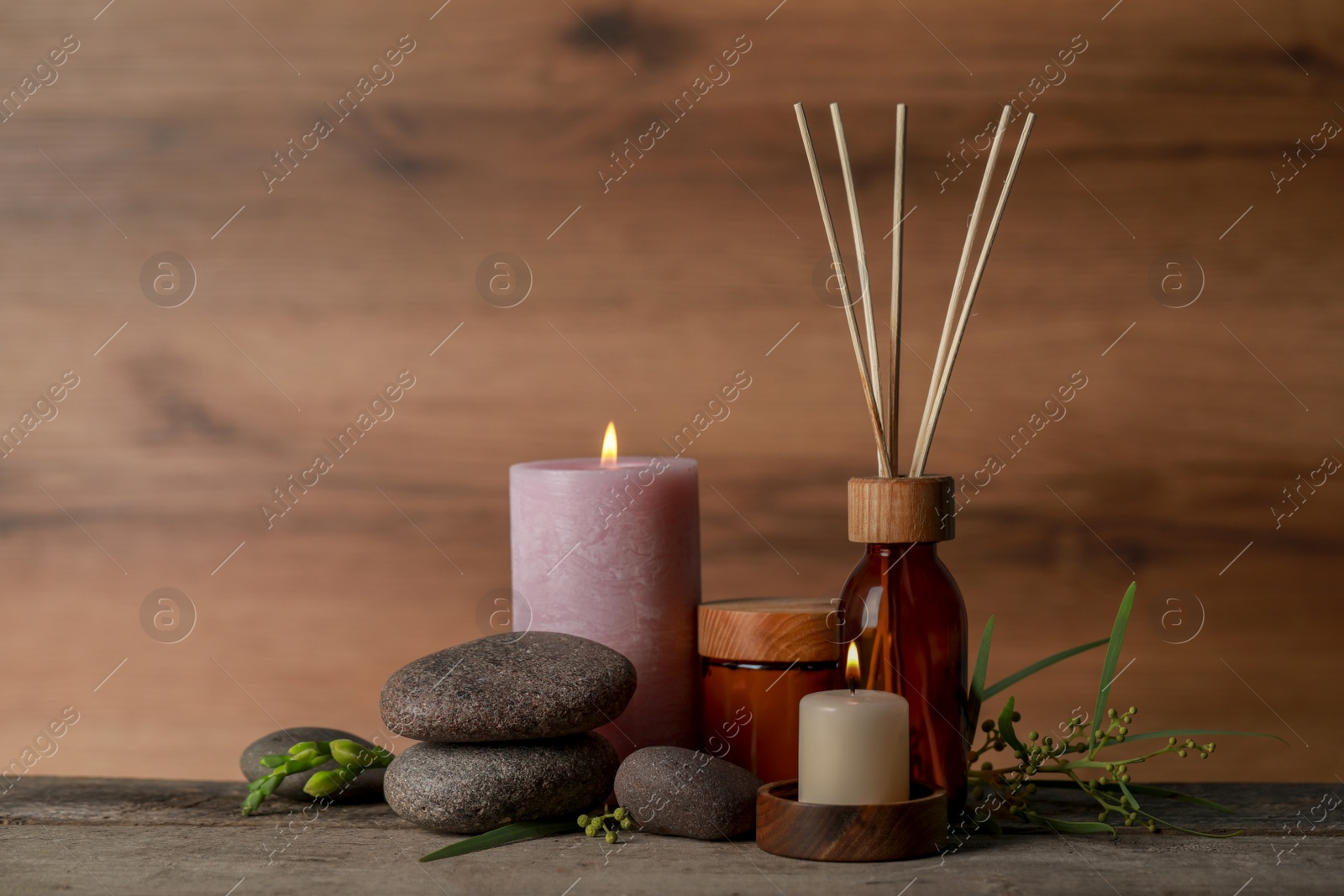 Photo of Beautiful spa composition with different care products and burning candles on wooden table