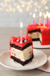 Piece of bento cake with tasty cream and burning candles on wooden table