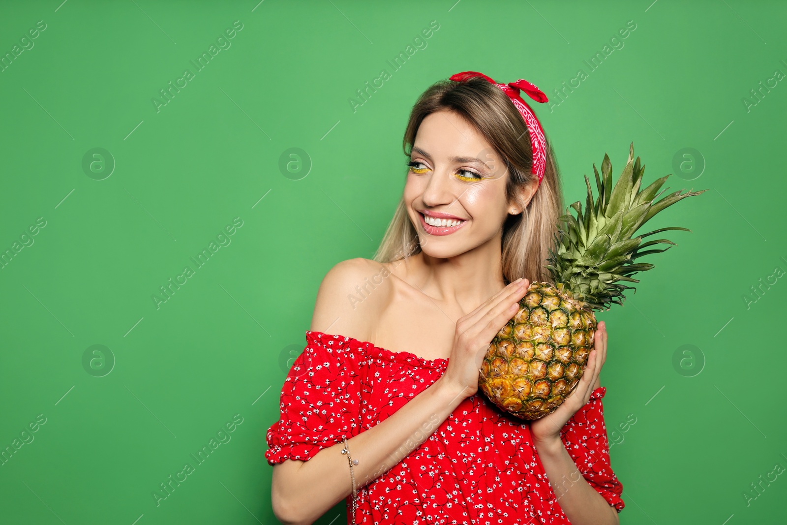 Photo of Young woman with fresh pineapple on green background, space for text. Exotic fruit