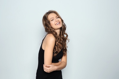 Portrait of beautiful young woman with shiny wavy hair on color background