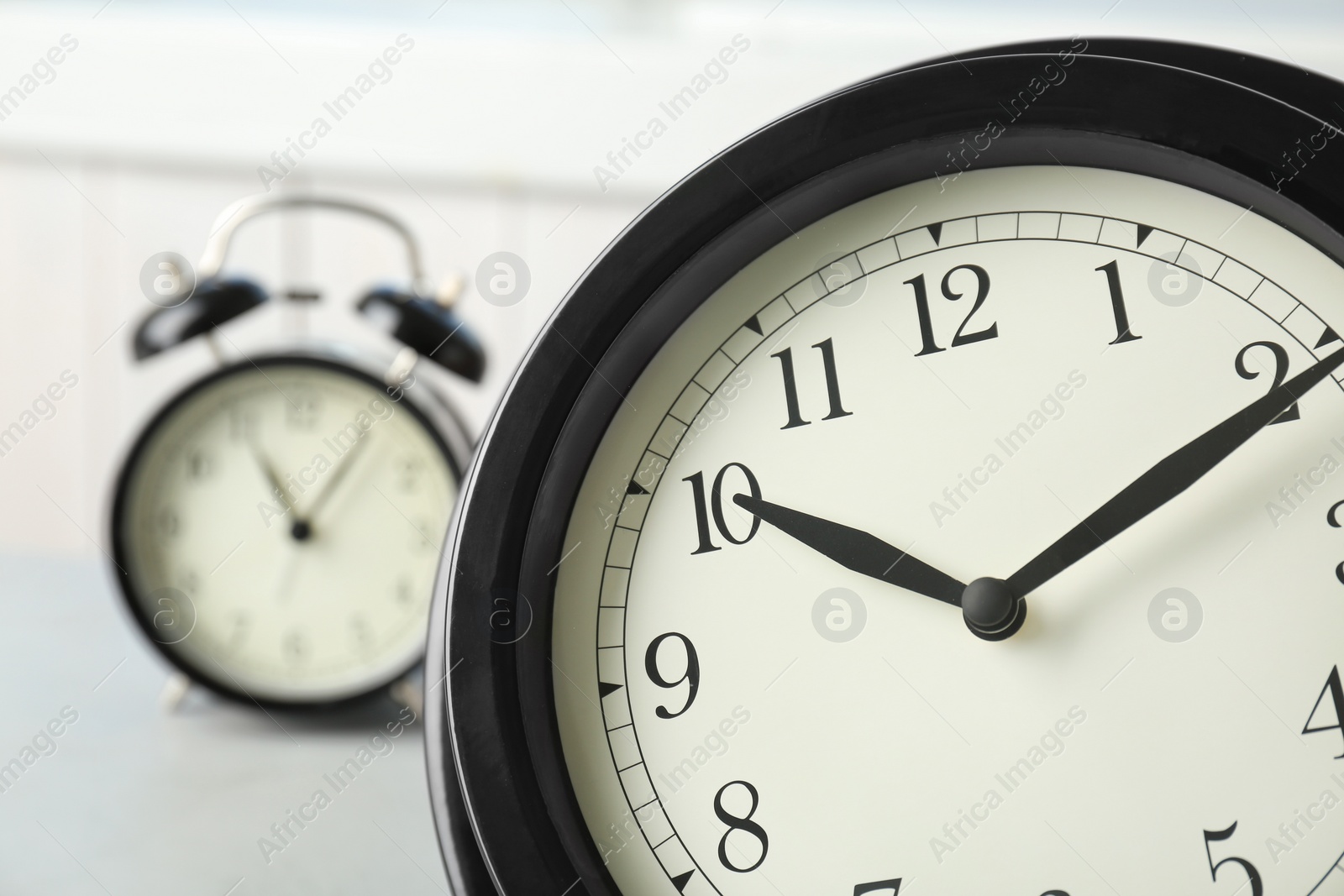 Photo of Black clocks on table. Time change concept