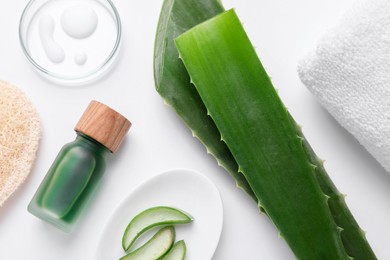 Flat lay composition with cosmetic products and cut aloe leaves on white background