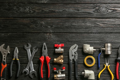 Photo of Flat lay composition with plumber's tools and space for text on wooden background