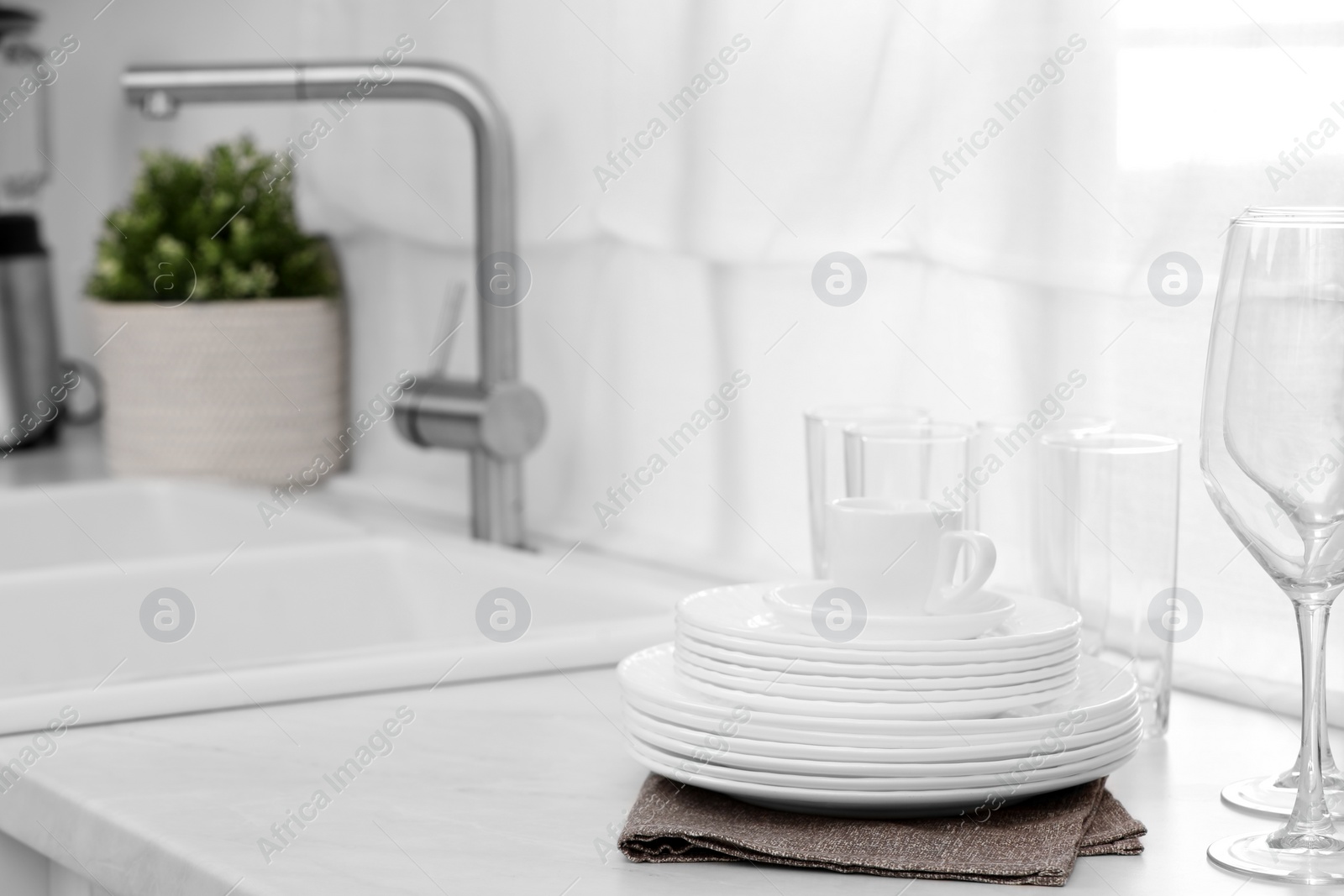 Photo of Clean dishes on light countertop near sink in kitchen, space for text