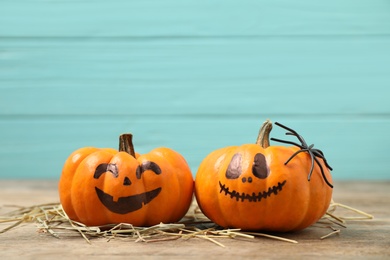 Photo of Pumpkins with scary faces on light blue wooden background, space for text. Halloween decor