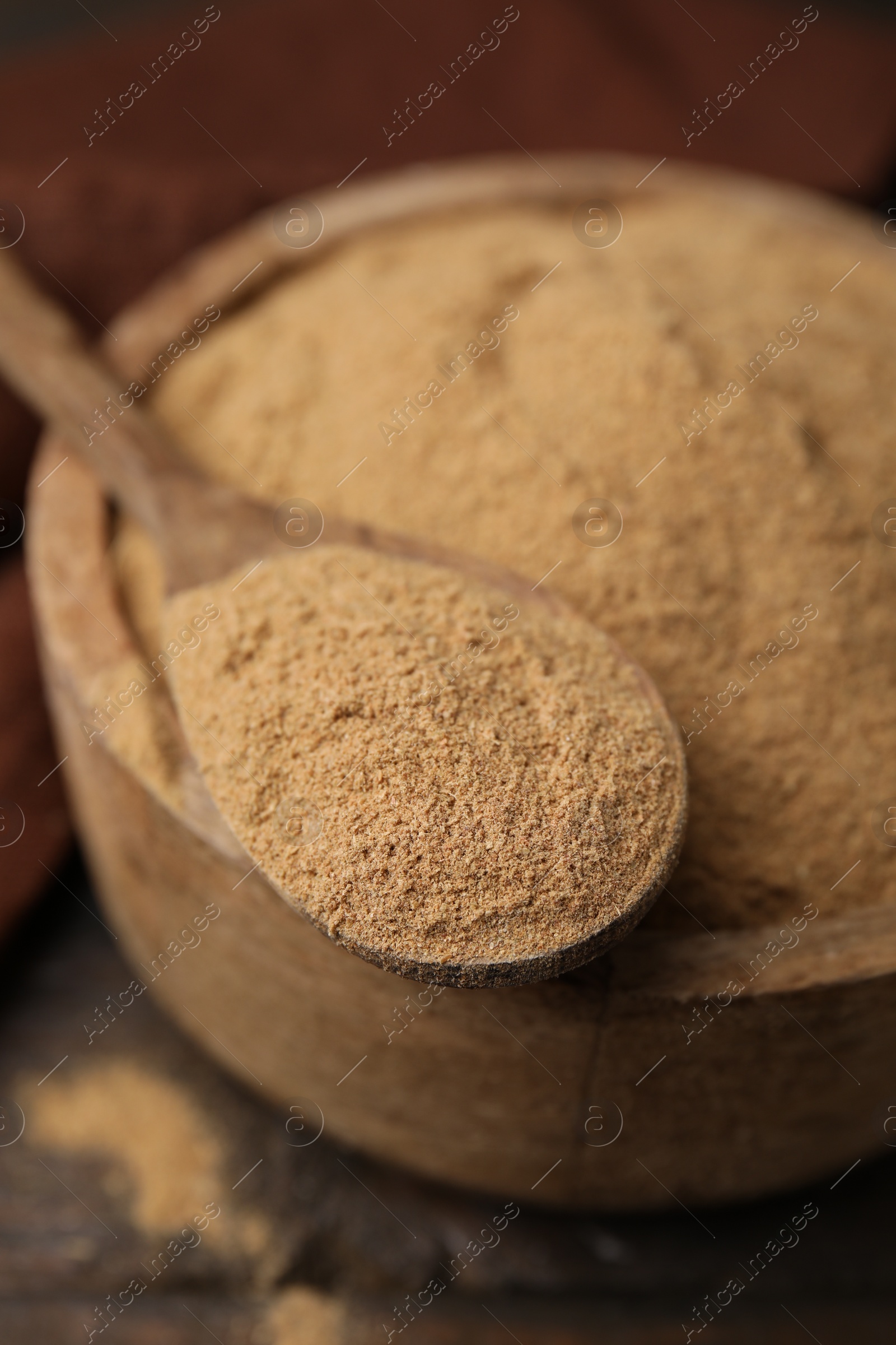 Photo of Dietary fiber. Psyllium husk powder in bowl and spoon on table, closeup