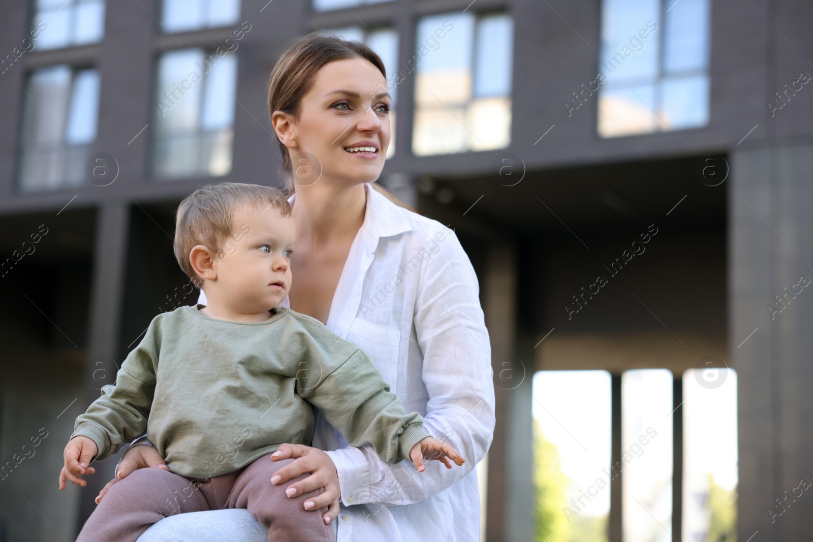 Photo of Happy nanny with cute little boy outdoors, space for text