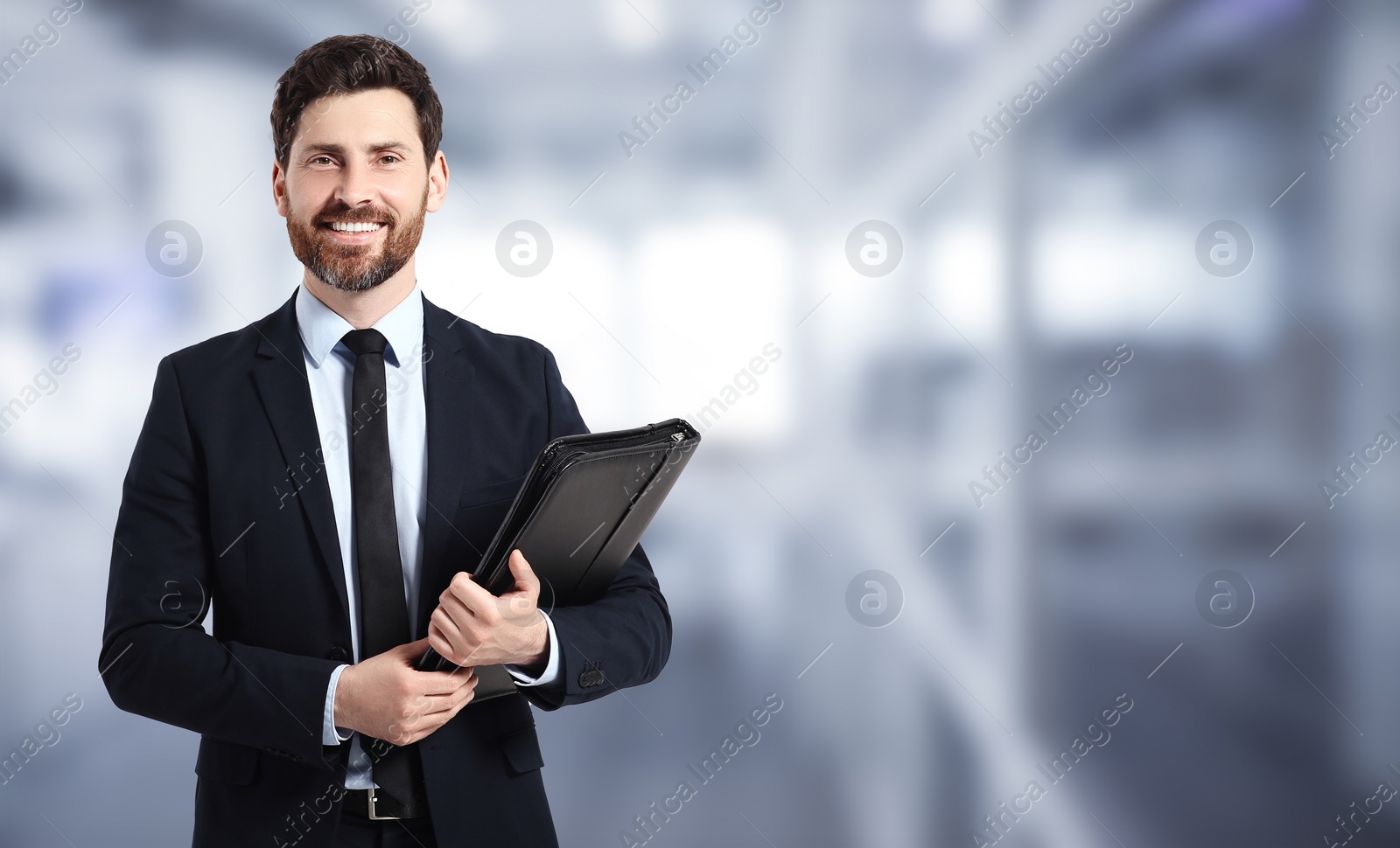Image of Handsome real estate agent with portfolio in office, space for text