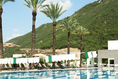 Photo of Outdoor swimming pool at luxury resort and beautiful view of mountains on sunny day