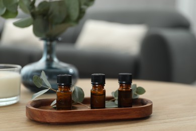 Aromatherapy. Bottles of essential oil and eucalyptus leaves on wooden table