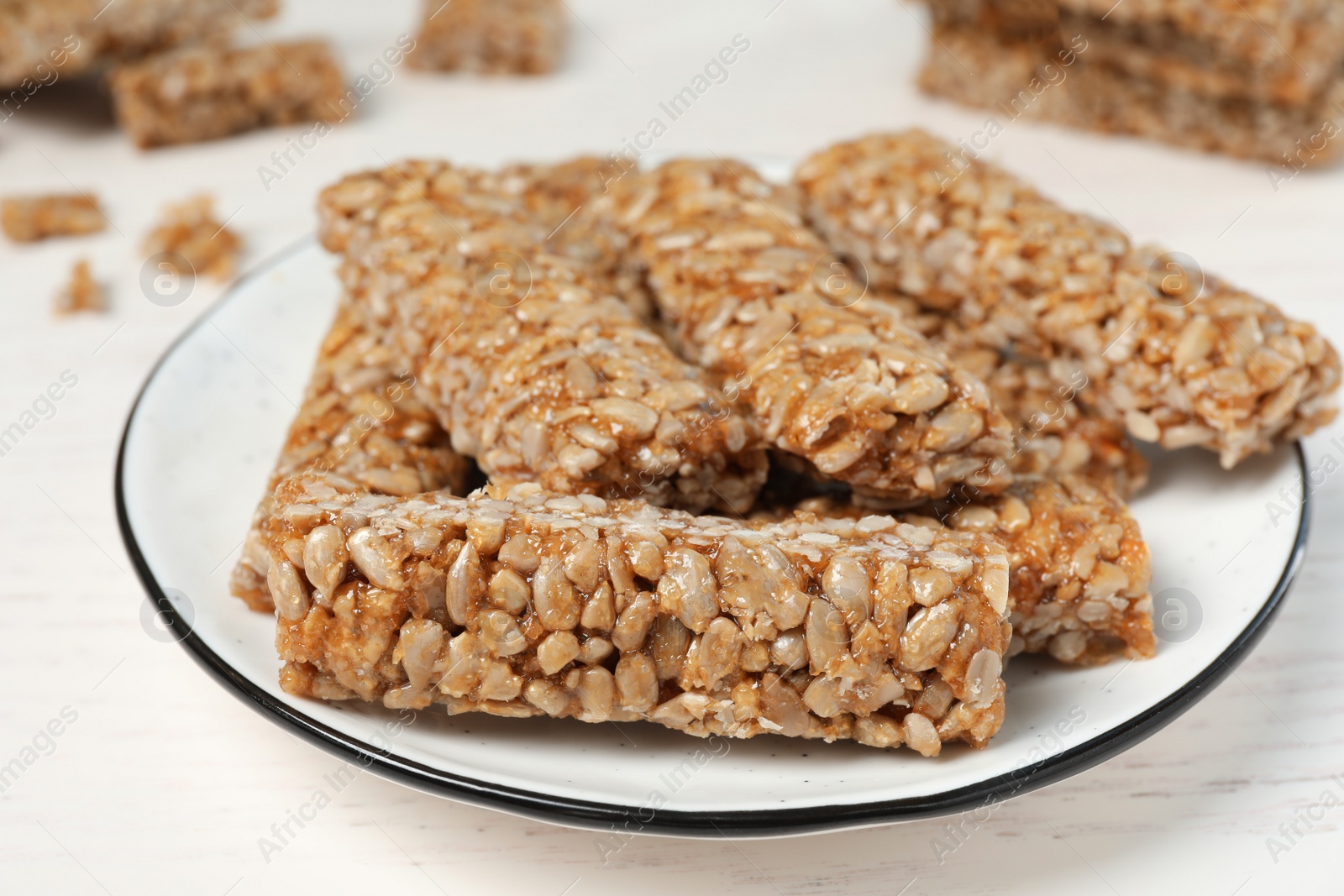 Photo of Delicious sweet kozinaki bars on white wooden table, closeup