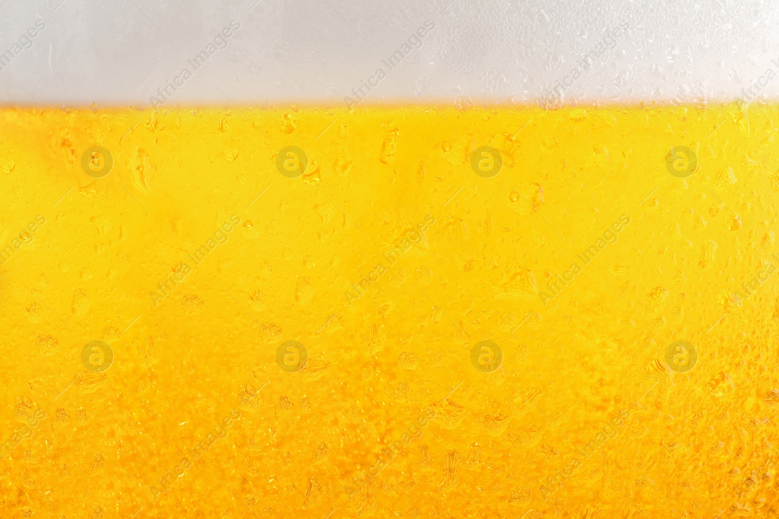 Photo of Glass of tasty cold beer with foam and condensation drops as background, closeup