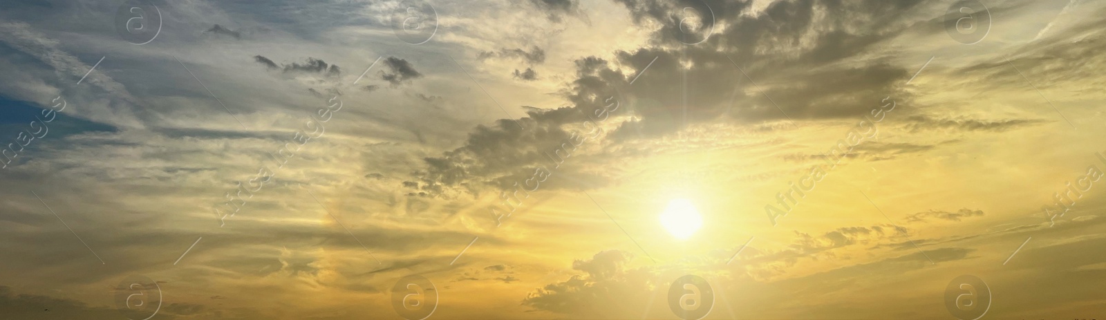 Image of Sun shining on beautiful cloudy sky at sunset, banner design