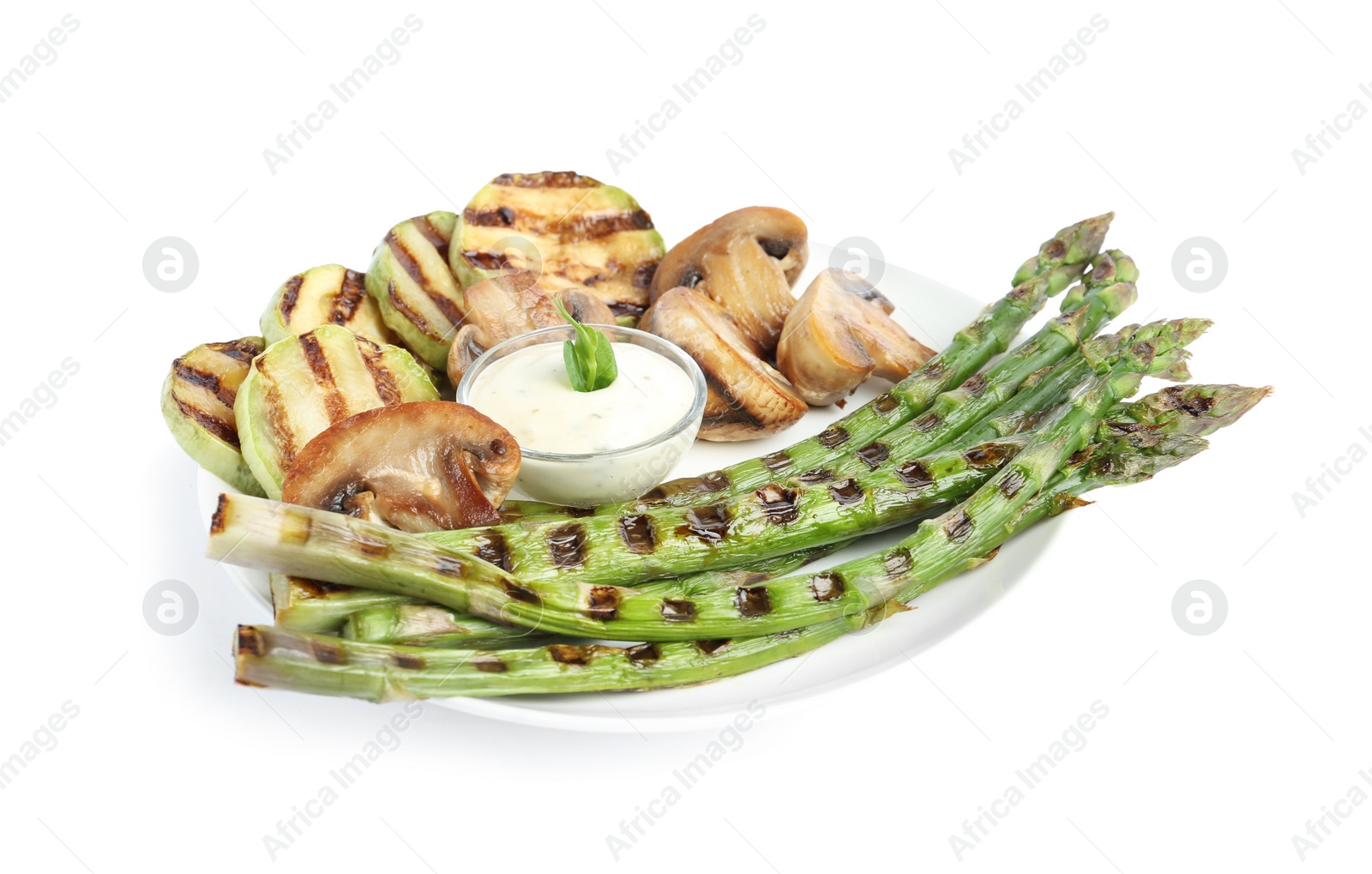 Photo of Tasty grilled asparagus with sauce, zucchini and mushrooms isolated on white