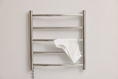 Photo of Heated towel rail with underwear on white wall