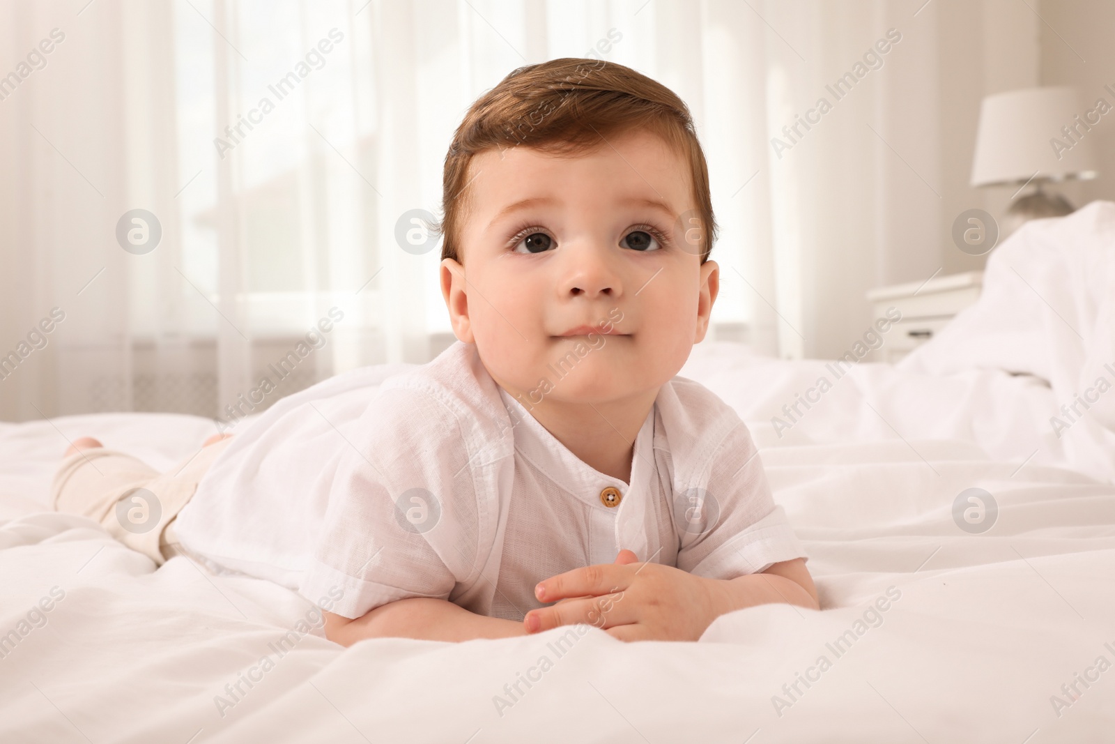 Photo of Cute baby boy on bed at home