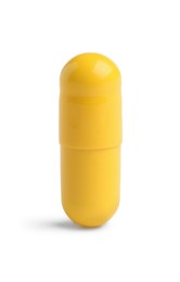 Photo of One yellow pill on white background. Medicinal treatment