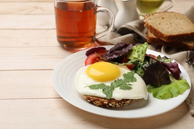 Photo of Delicious breakfast with fried egg and salad served on light wooden table. Space for text