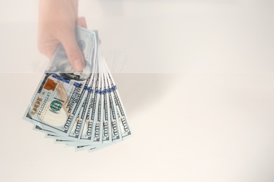 Photo of Teller with money at cash department window, top view. Space for text