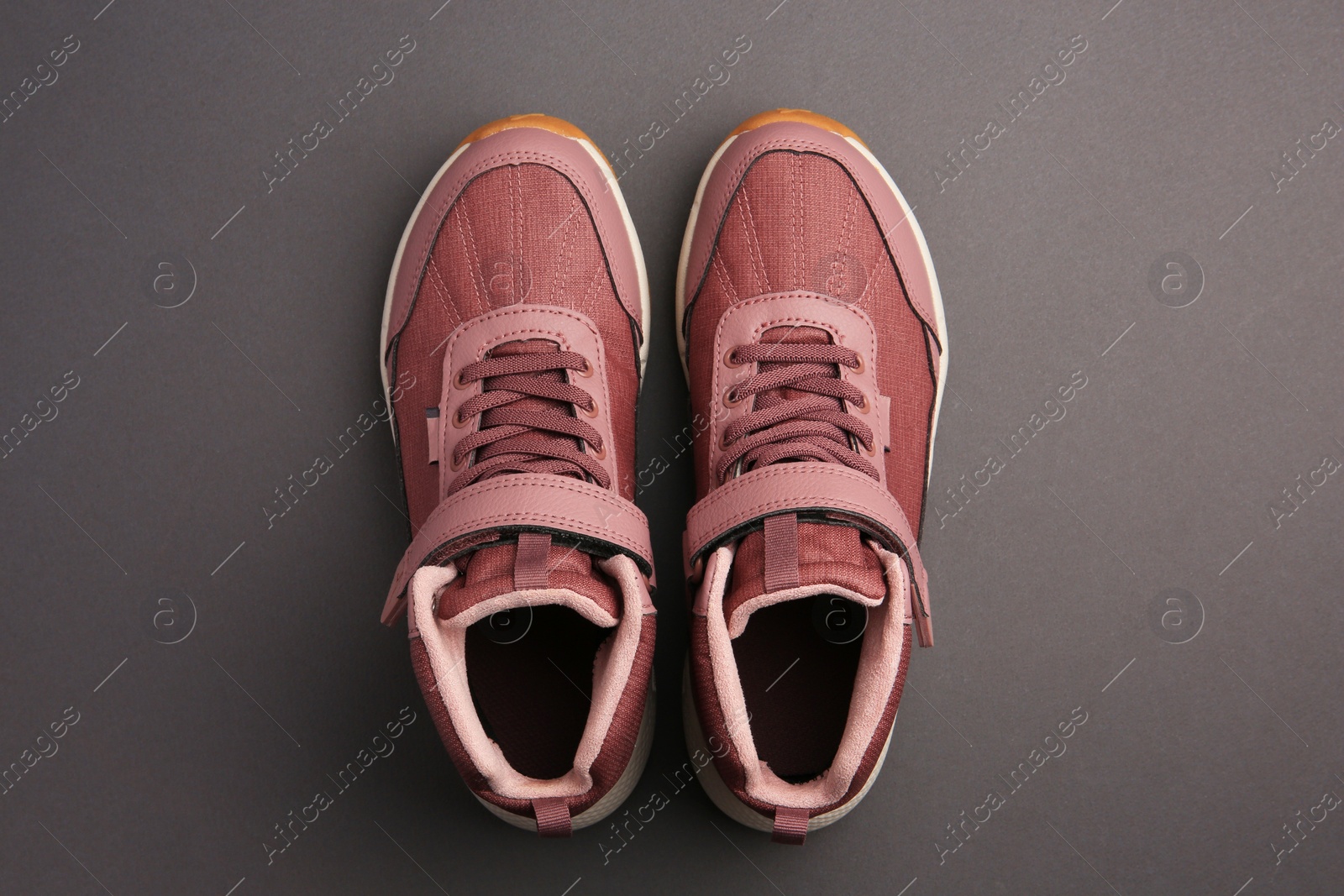 Photo of Pair of stylish kid's sneakers on black background, top view