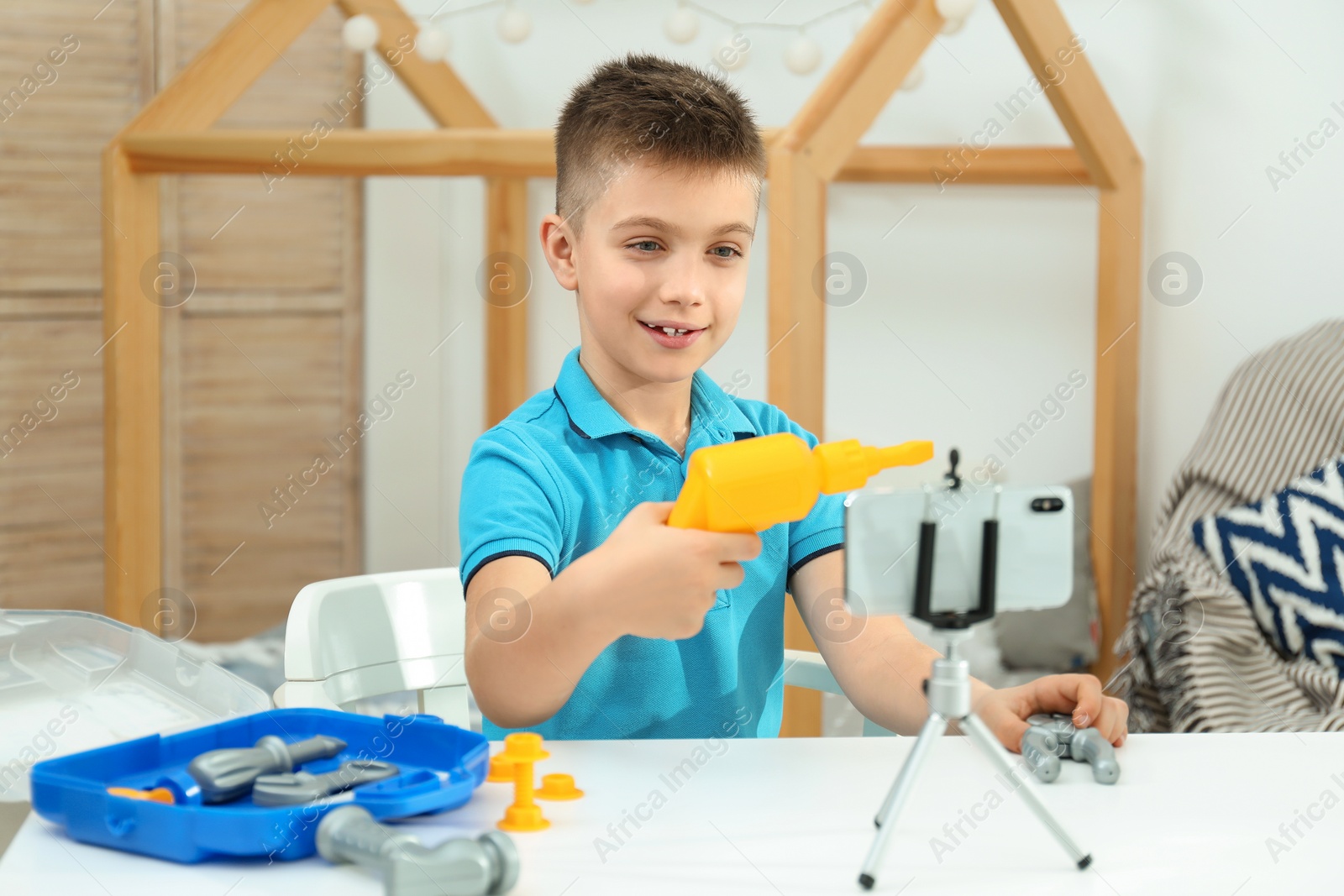 Photo of Cute little blogger with toy recording video at home